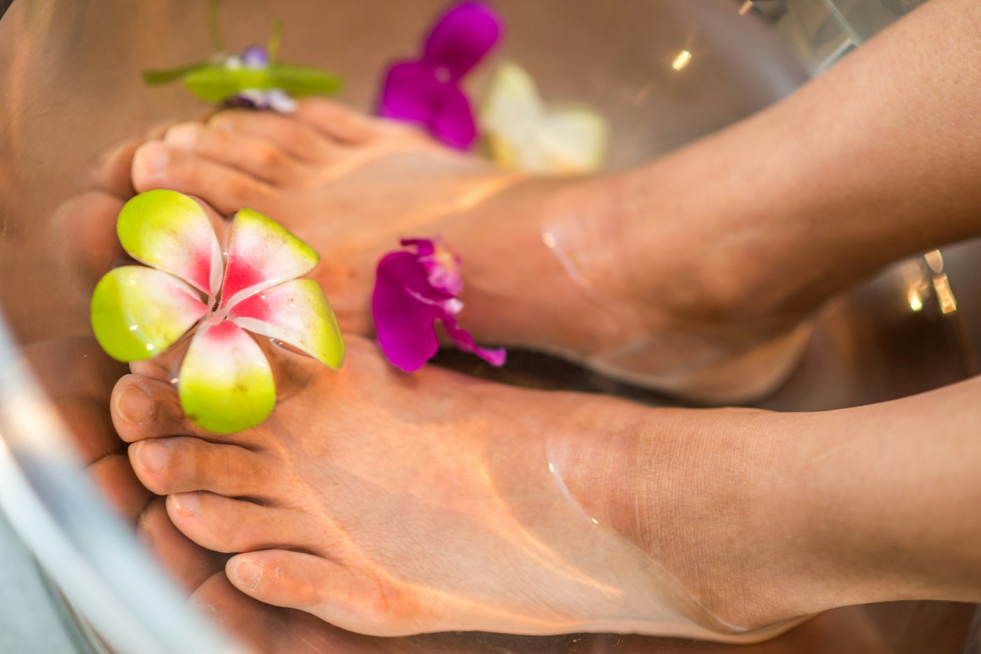 Spa pedicure with fresh flowers in a warm foot soak